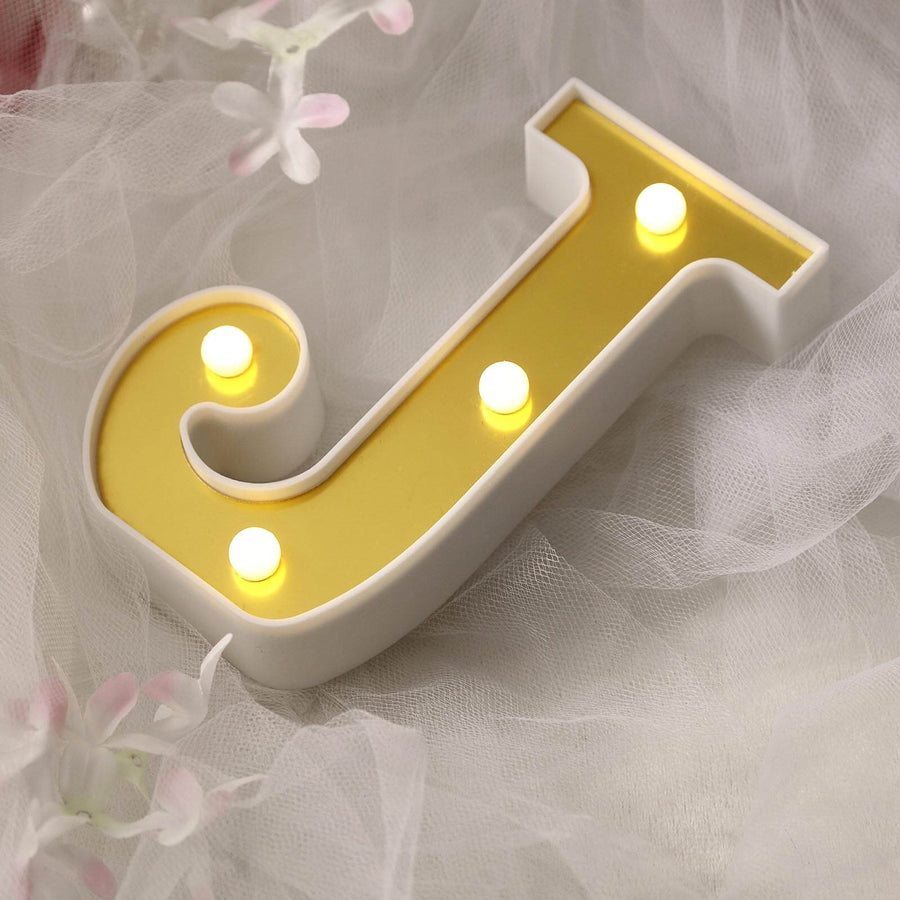 Decorative yellow letter J light with white base and glowing bulbs.