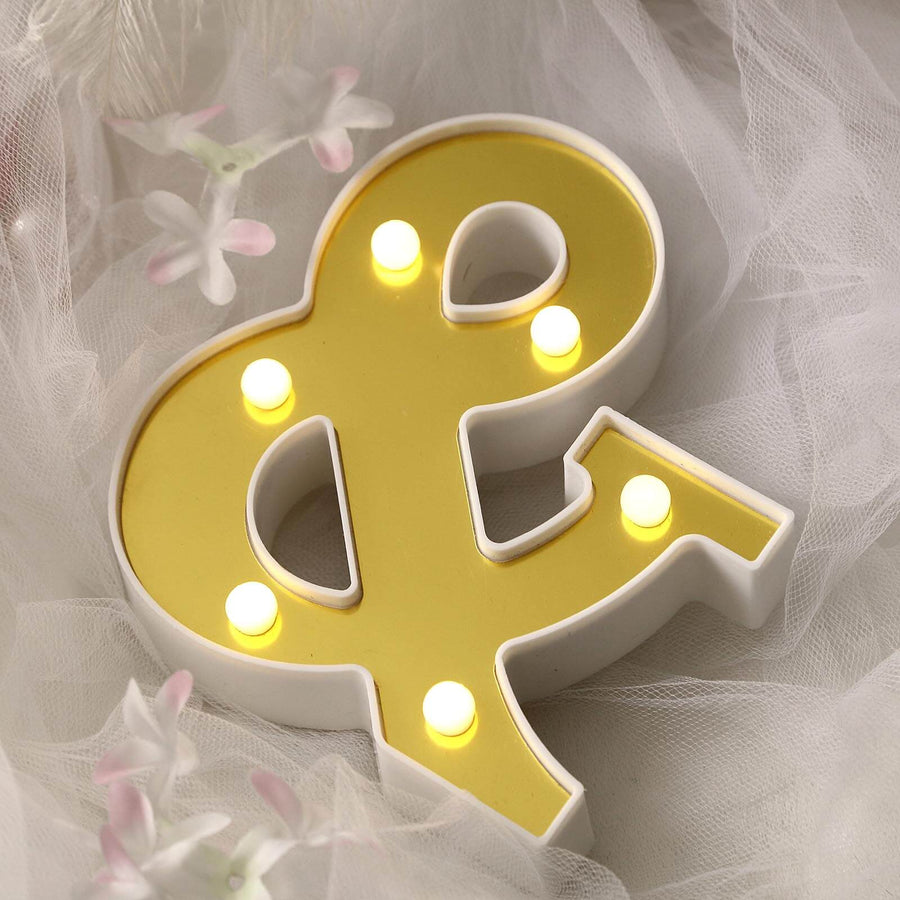 Yellow ampersand light decor with bulbs on a soft backdrop.