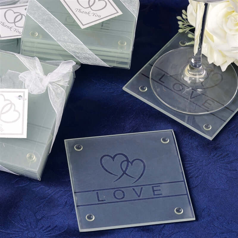 Acrylic coasters with love design and thank you tags on a blue tablecloth.