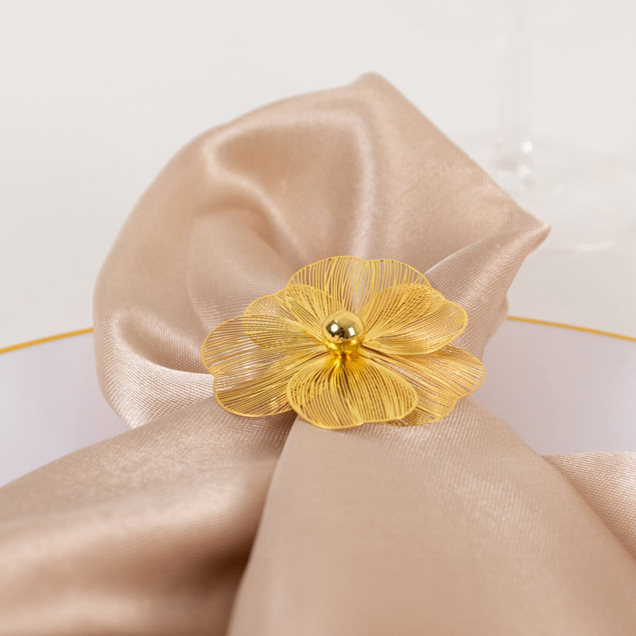 Gold floral napkin ring on a satin napkin.