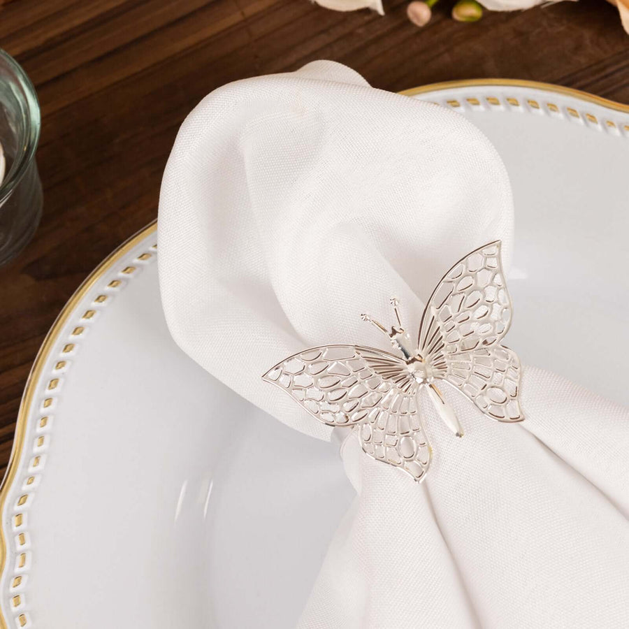 Elegant silver butterfly napkin holder on a white napkin.