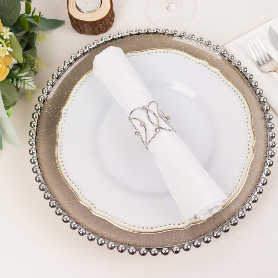 Elegant dinner plate with silver beaded charger and napkin holder.