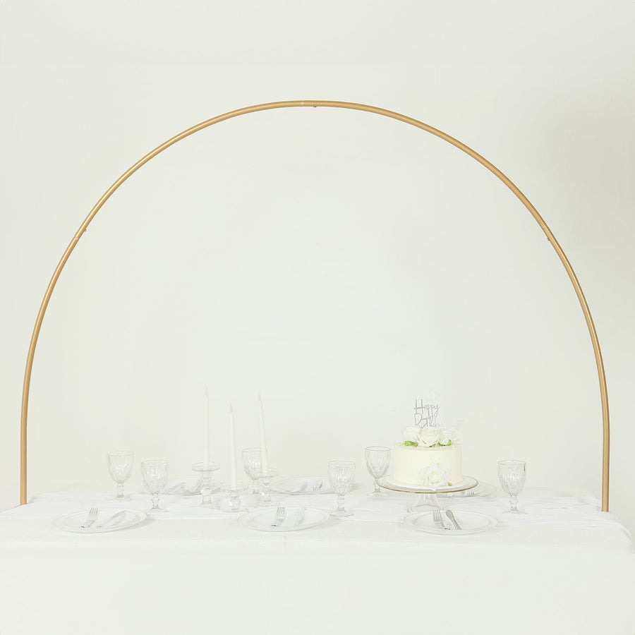 Elegant table setting with cake and glassware under an arch.