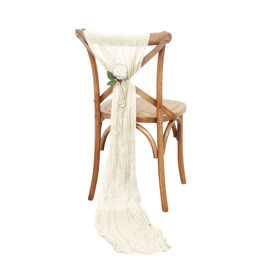 Elegant ivory table scarf draped on a wooden chair with floral accent.