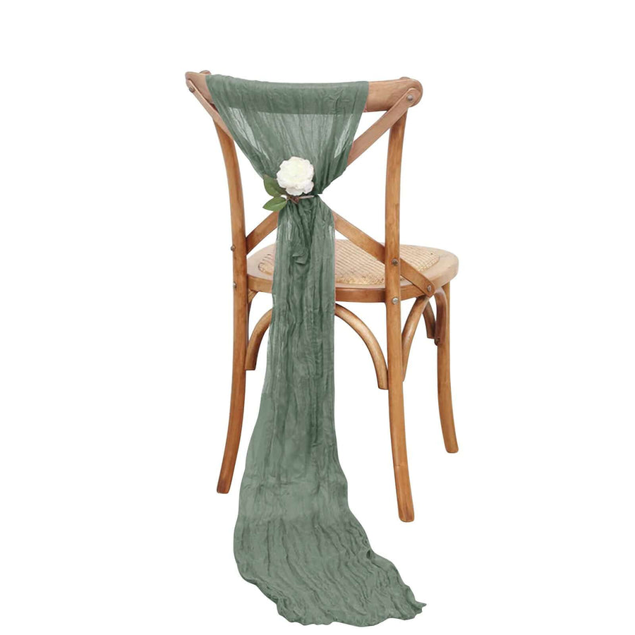 Green fabric draped on a wooden chair with a flower accent.