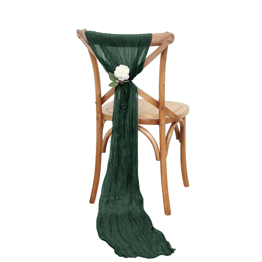 Green scarf draping elegantly on a wooden chair with a floral accent.
