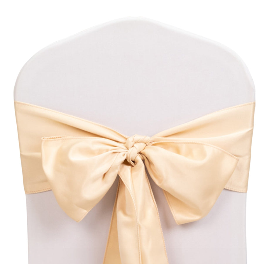 Beige satin chair bow tied on a white chair cover