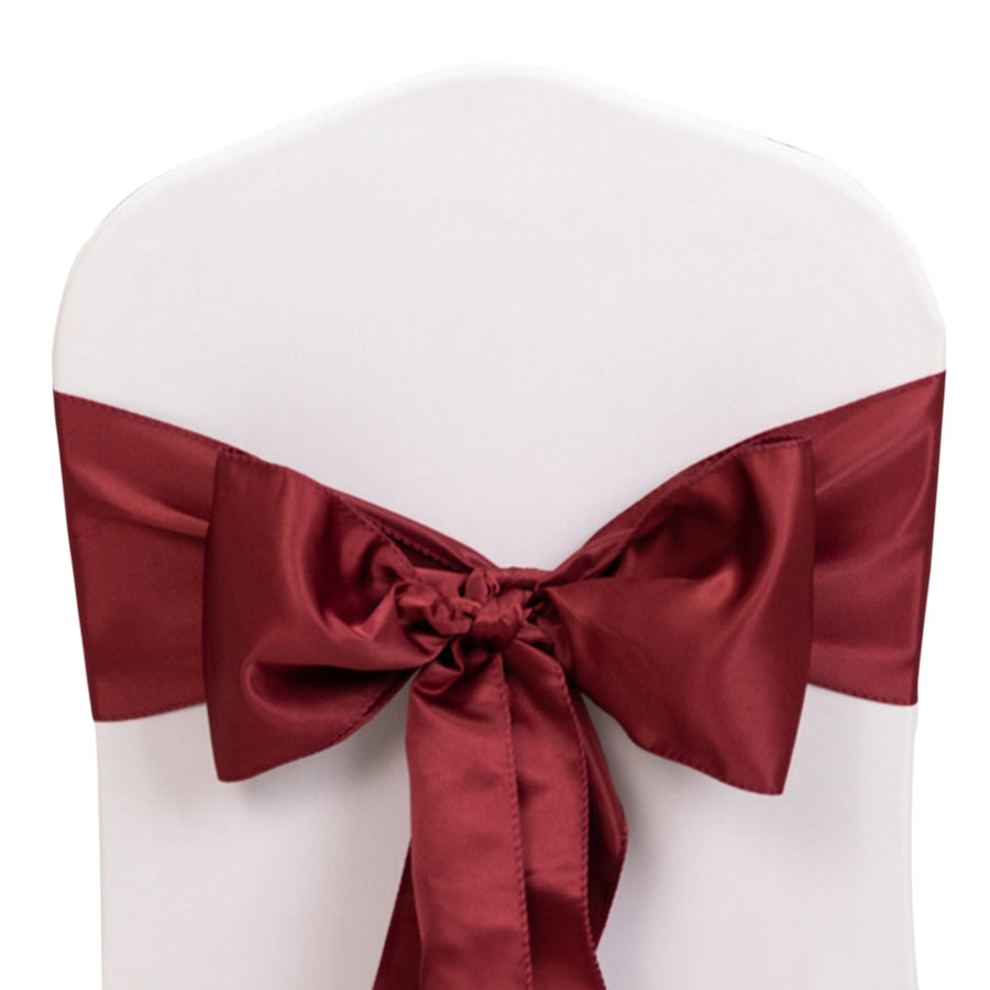 Burgundy satin chair bow tied on a white chair
