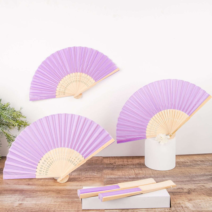 Purple folding fans displayed on a wooden surface with decorative elements.