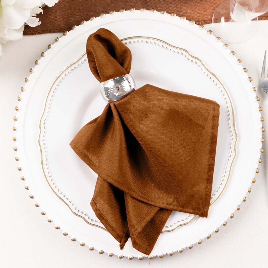 Brown napkin elegantly arranged on a decorative plate setting.