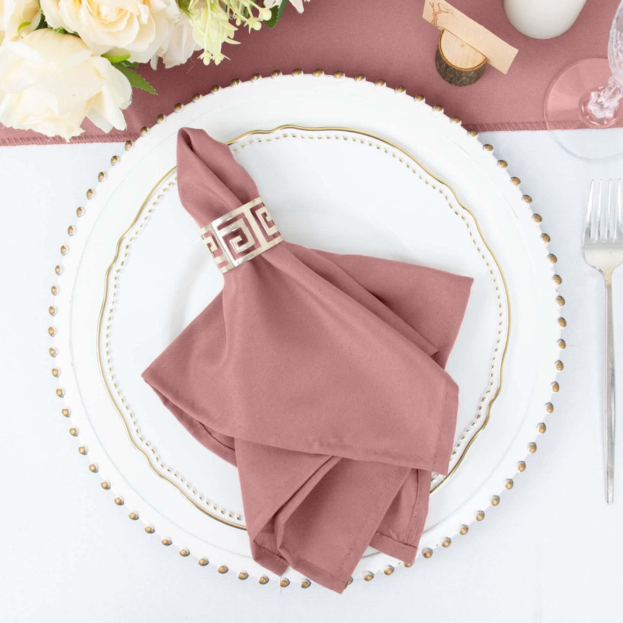 Rose napkin with decorative ring on an elegant plate setting.
