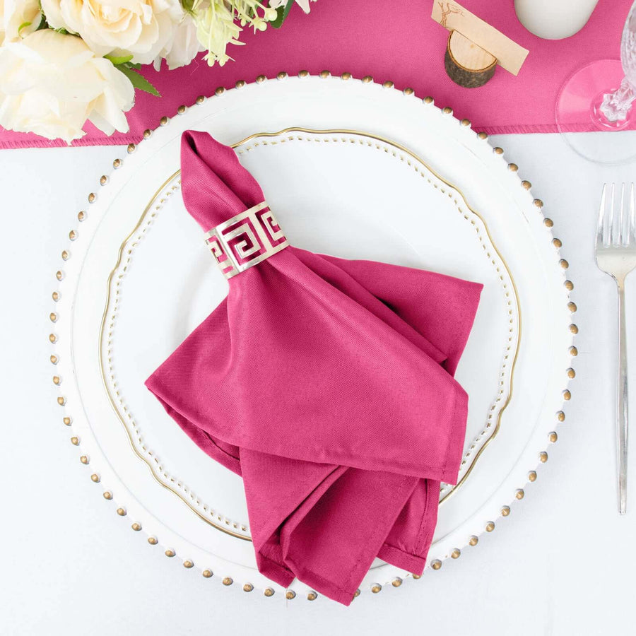 Elegant magenta napkin with decorative ring on a white plate