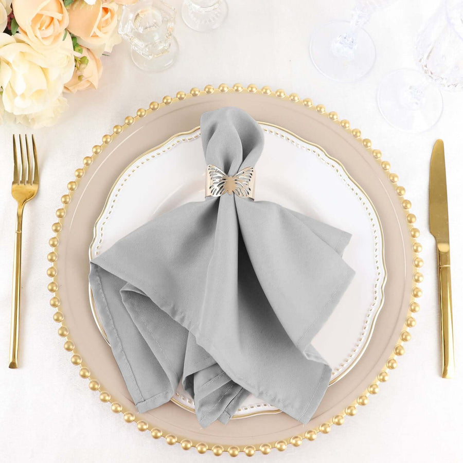 Elegant gray napkin with silver napkin ring on a decorative plate.