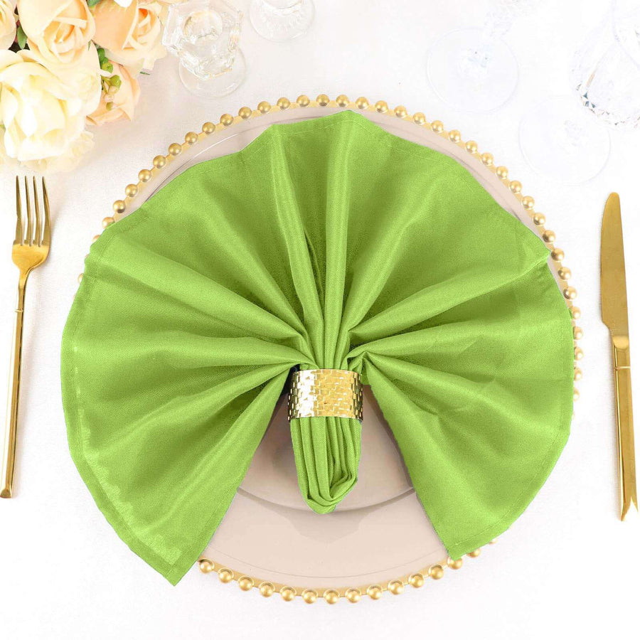 Green napkin elegantly folded on a decorative plate with gold accents.