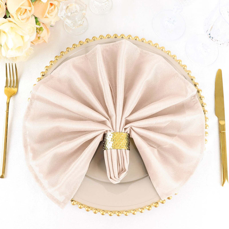 Elegant beige napkin with gold ring on a decorative plate setting.