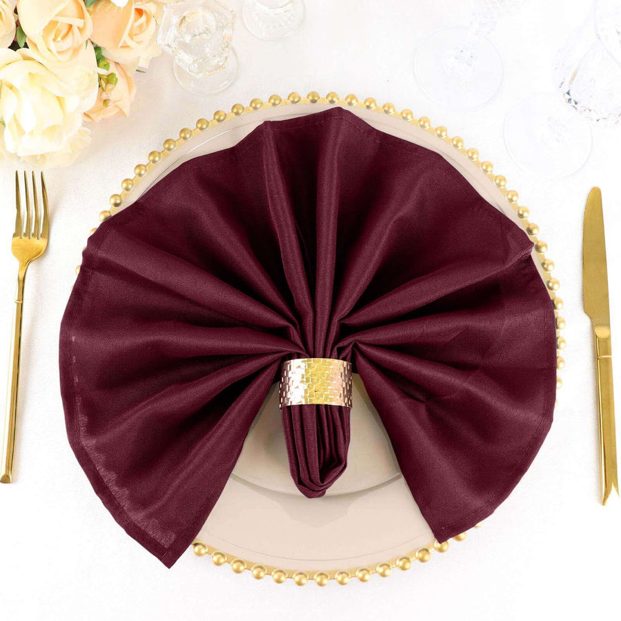 Burgundy napkin elegantly folded on a decorative plate with gold accents.