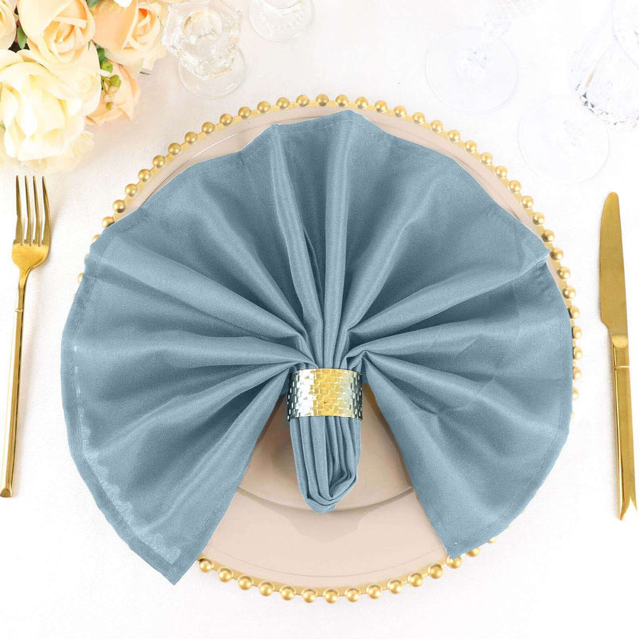 Elegant blue napkin elegantly folded on a plate with gold trim.