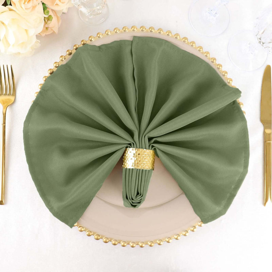 Elegant green napkin with gold ring on a decorative plate.
