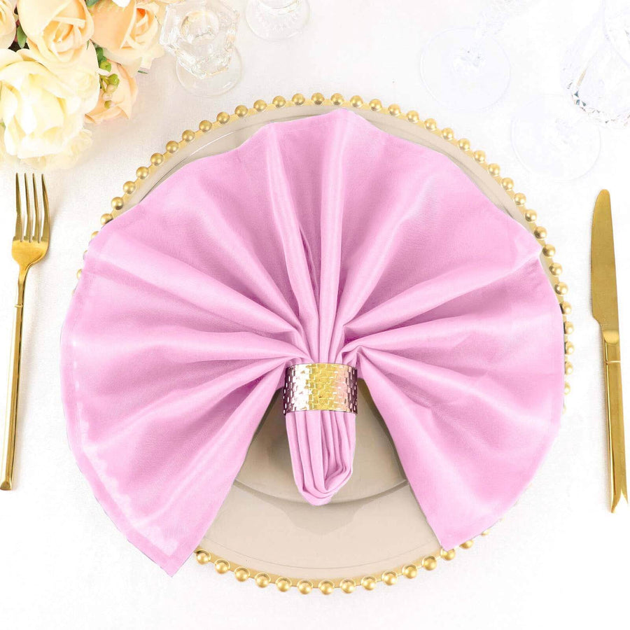 Pink napkin elegantly arranged on a decorative plate with golden accents.