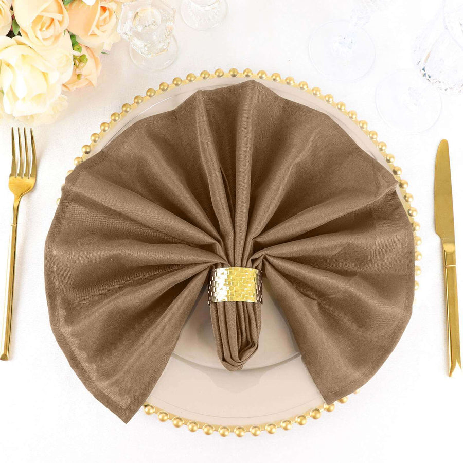 Elegant brown napkin folded on a decorative plate with gold accents.