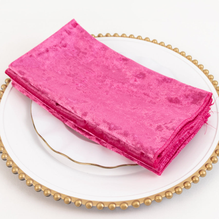 Pink velvet napkins stacked on a decorative plate.