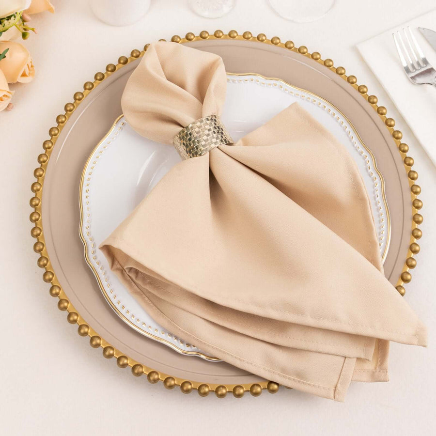 Beige napkin elegantly arranged on a decorative plate with a gold rim.