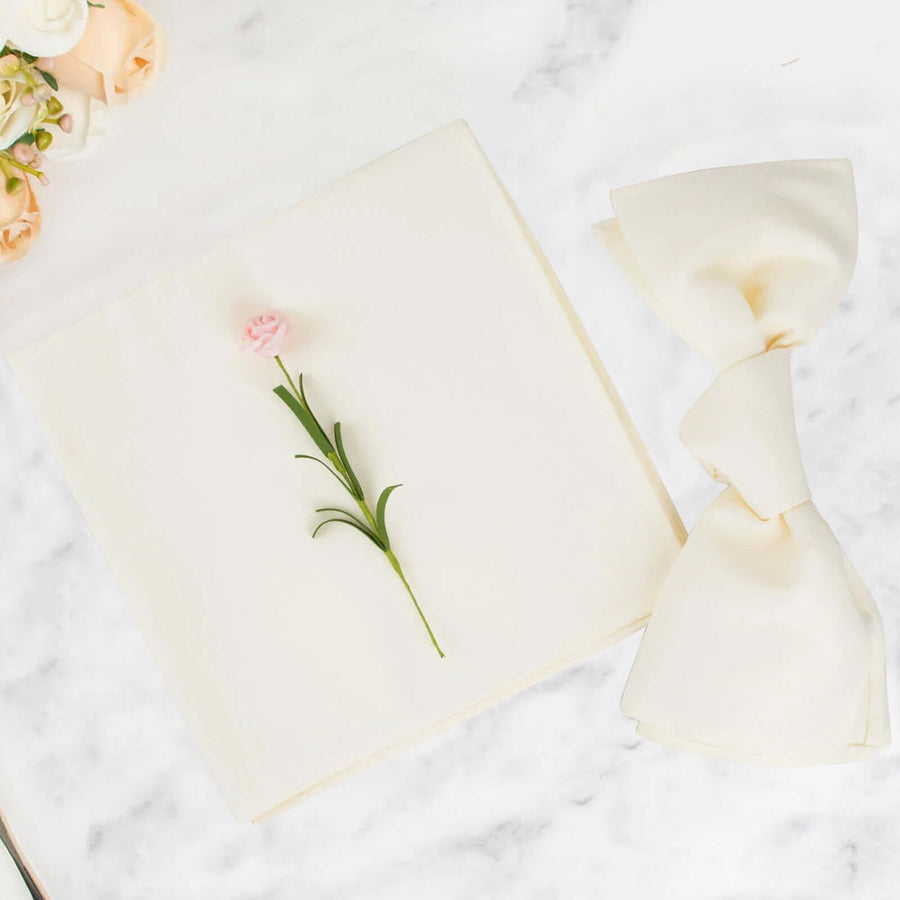 Elegant cream napkin with a pink flower and bow on a marble surface.