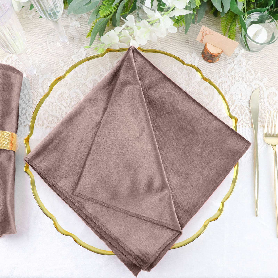 Brown satin napkin elegantly folded on a gold charger plate.