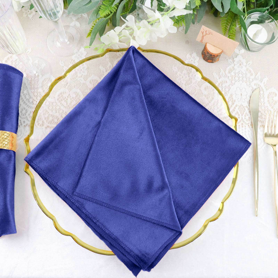 Navy blue cloth napkin on a decorative gold plate.