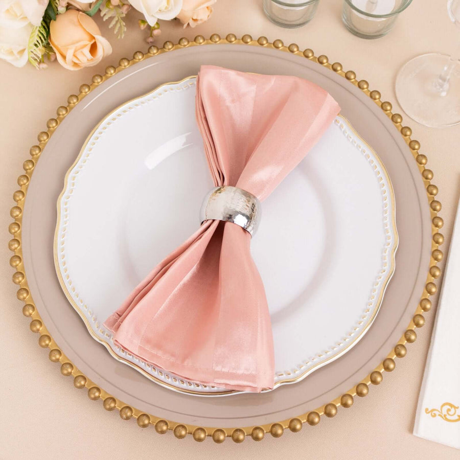 Elegant table setting with pink napkin and decorative plate.