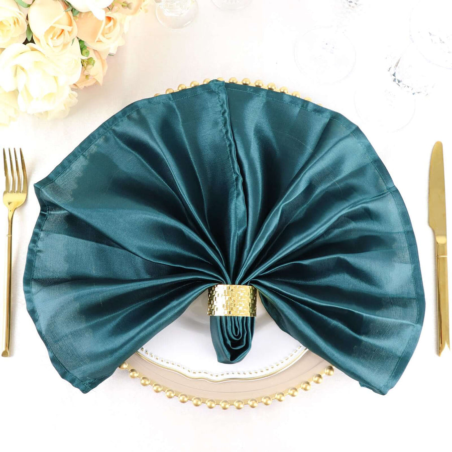 Teal satin napkin elegantly arranged on a decorated dinner plate