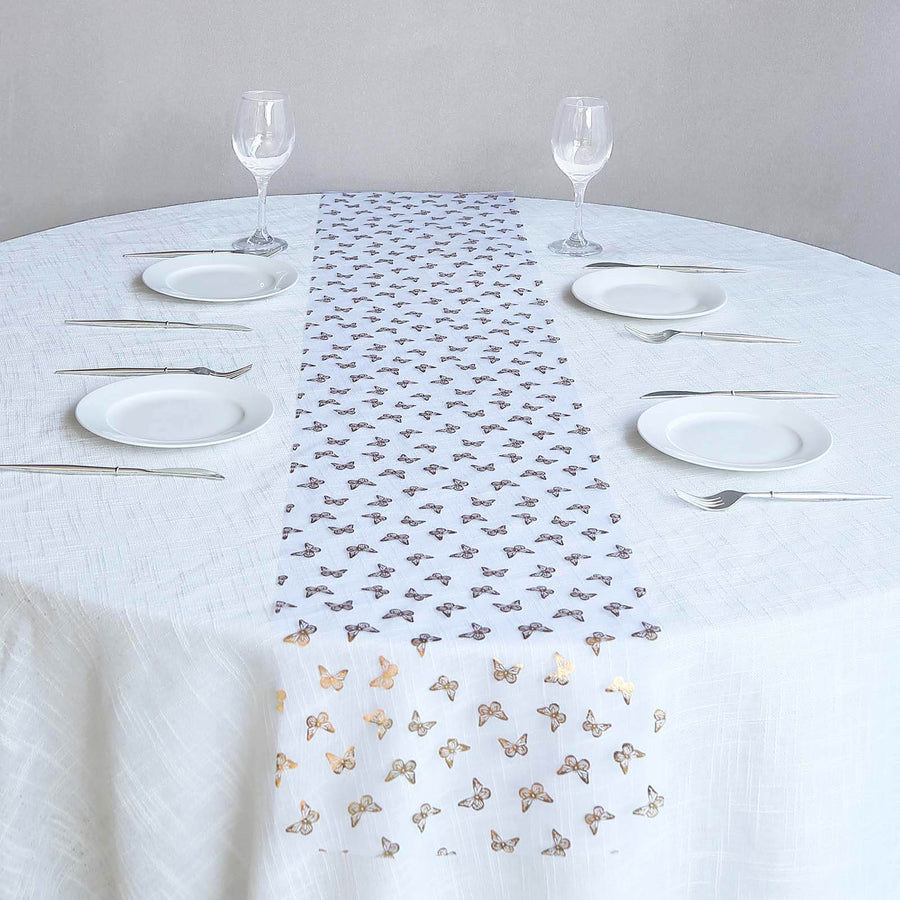 Butterfly-patterned table runner on a white table setting with plates and glasses.