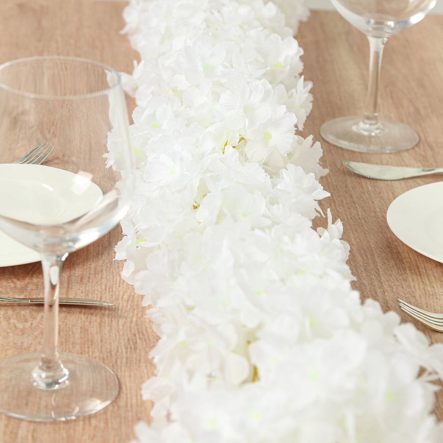 White floral table runner on a wooden dining table setting.
