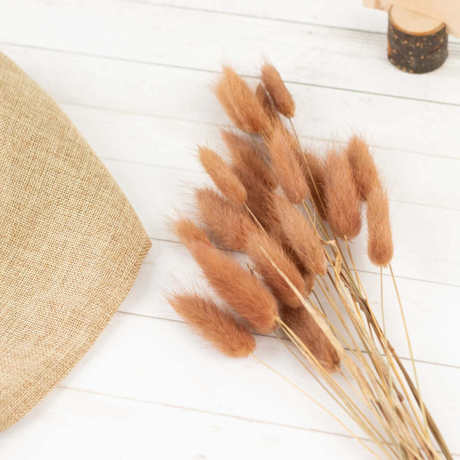 Dried fluffy grass stems in a rustic setting with burlap