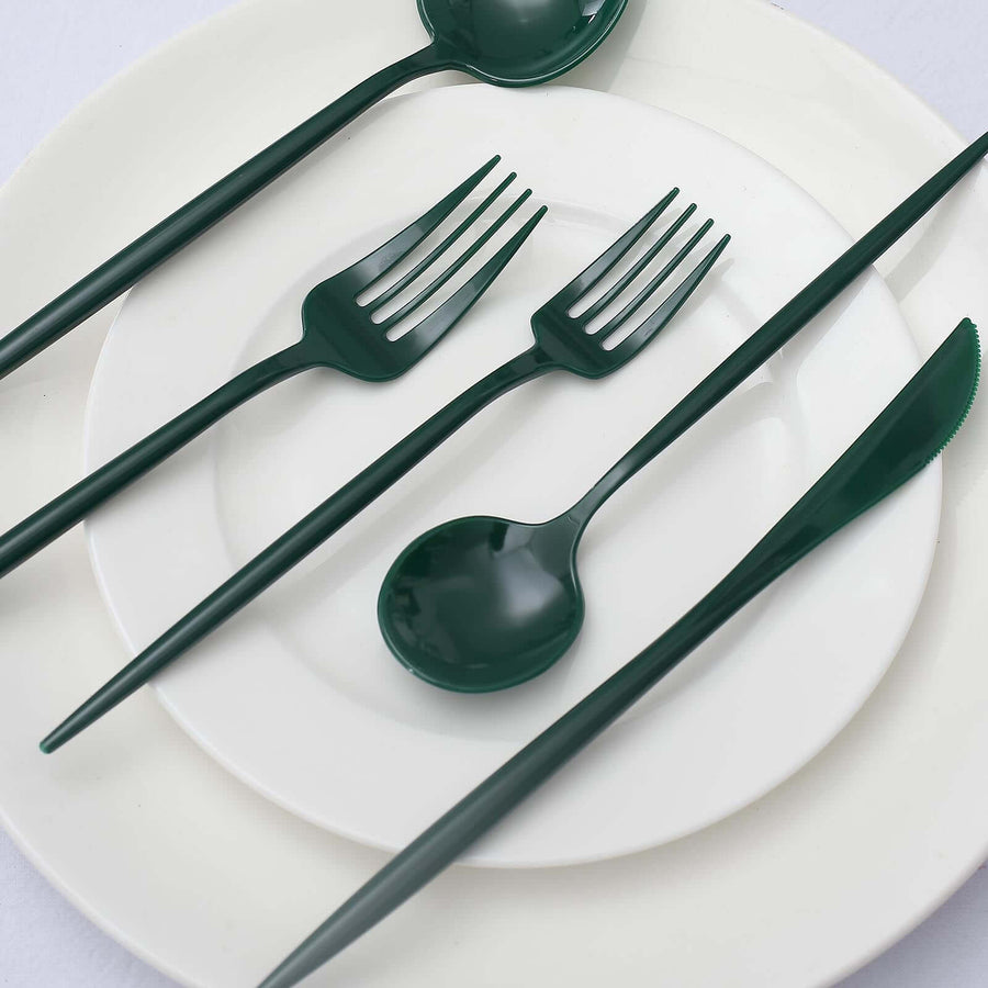 Green plastic cutlery set on white plates