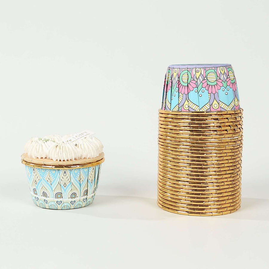 Decorative cupcake liners in blue and gold, stacked with a cupcake on the side.