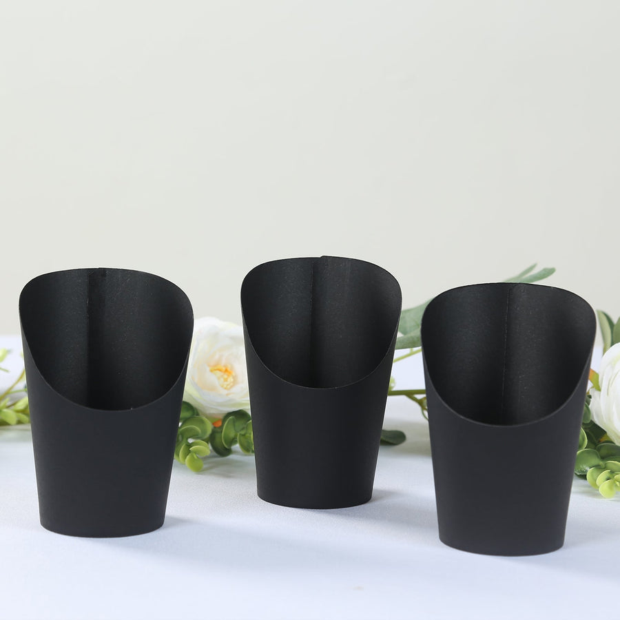 Black paper cups in a row against a light backdrop