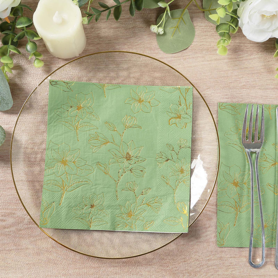 Floral patterned green napkin on a glass plate with utensils, styled table setting.