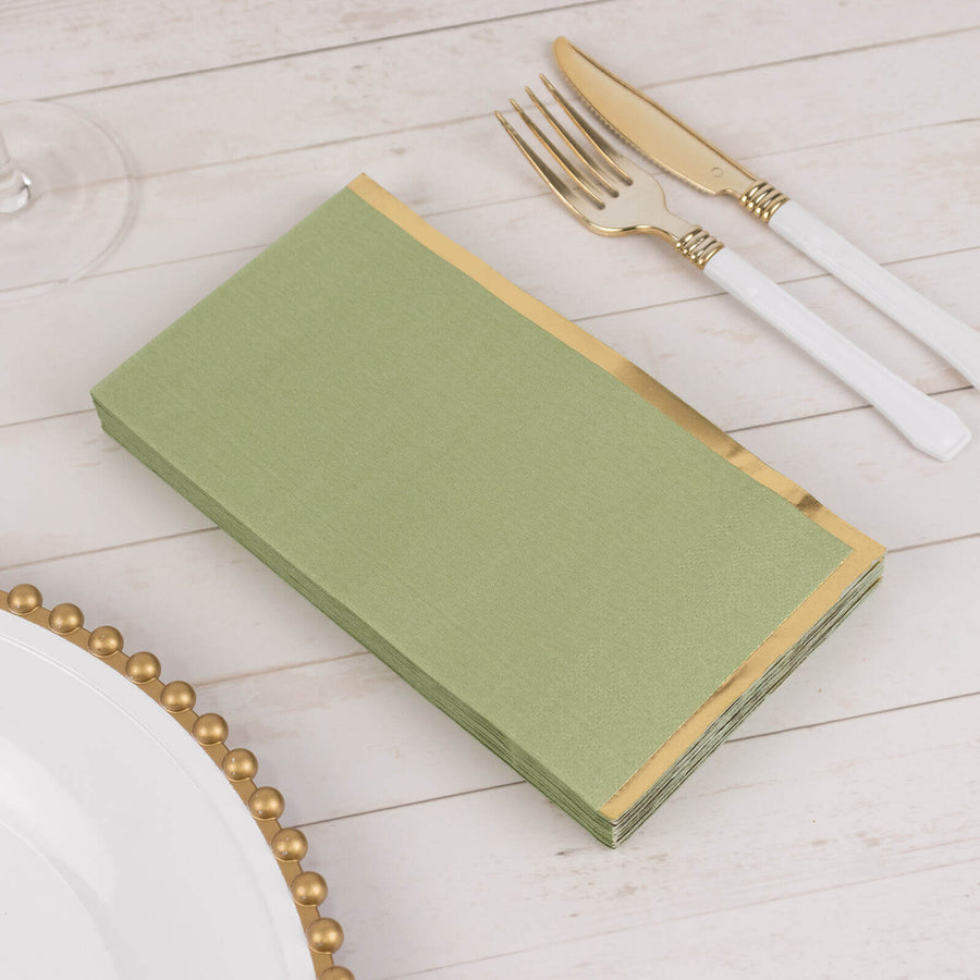 Green napkin with gold trim on a dining table setting.
