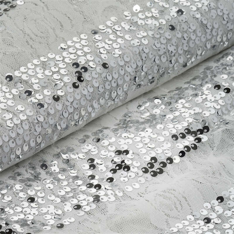 Silver sequin fabric with lace detail, showcasing a shimmering texture.