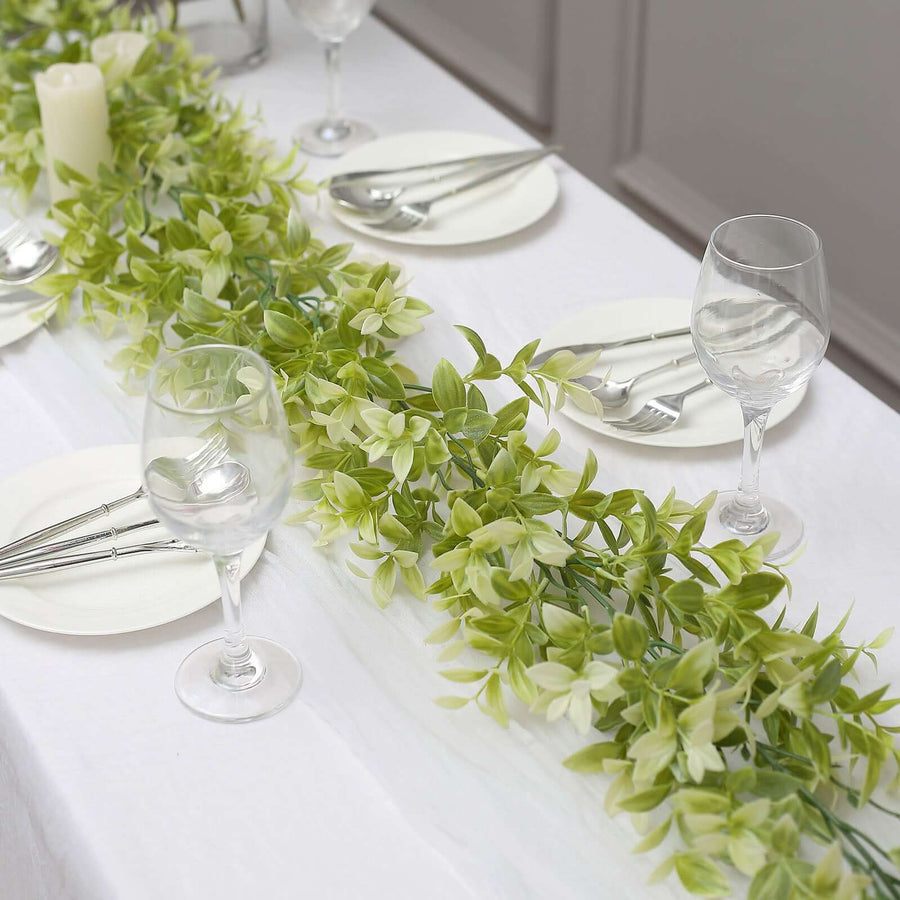 Elegant table setting with greenery, plates, and glassware for a dining occasion.