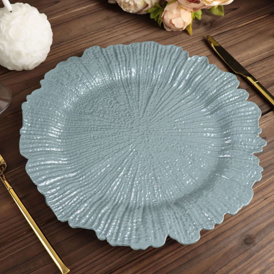 Blue textured plate on a wooden table with gold utensils.