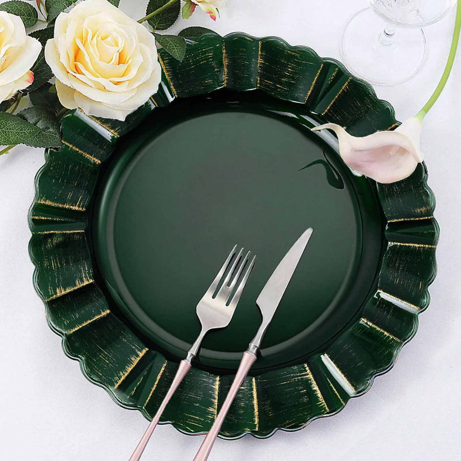 Elegant dark green scalloped plate with silver cutlery and floral accents.