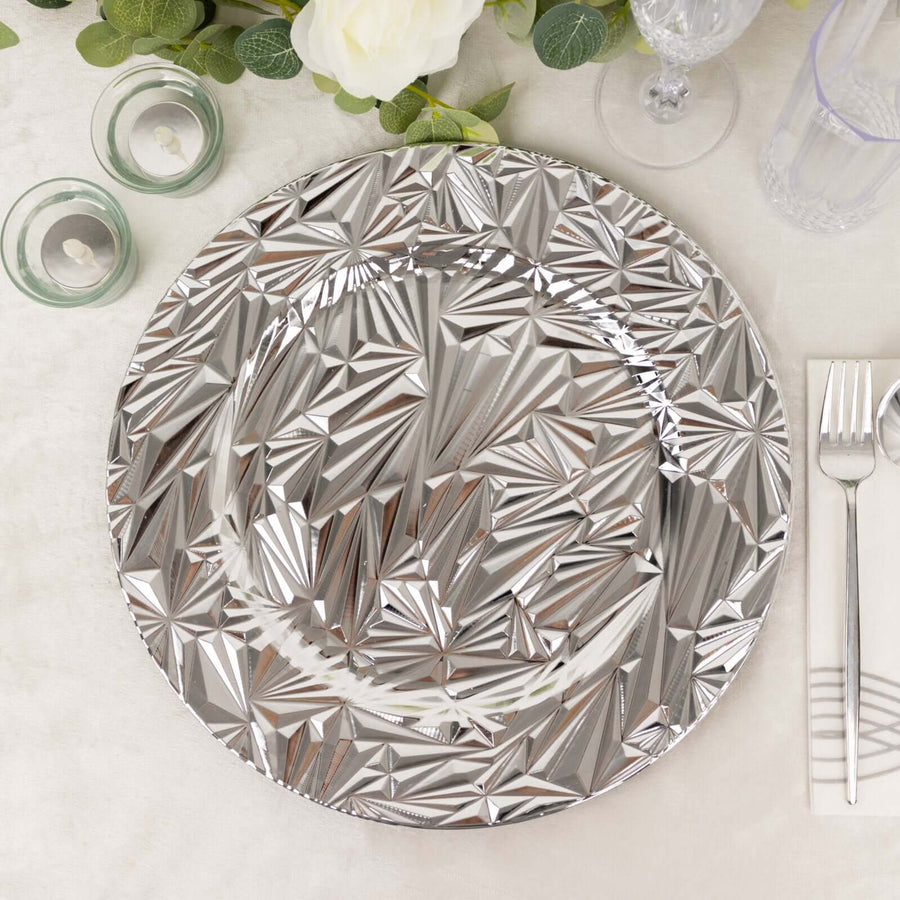 Decorative silver charger plate with geometric design on a dining table setting.