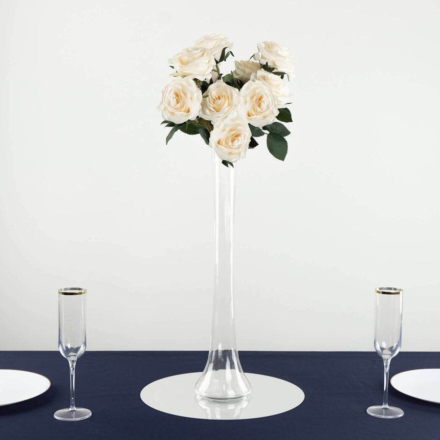 Elegant white rose arrangement in a tall glass vase on a table.