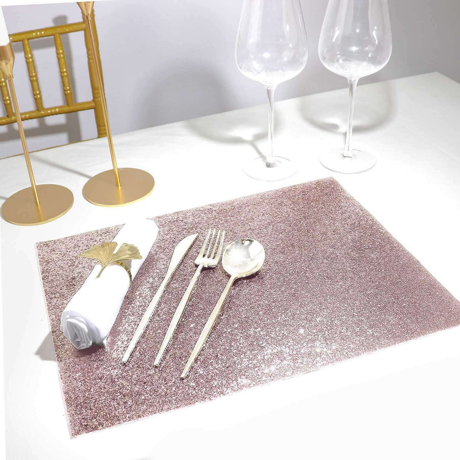 Rose gold glitter placemat with silver cutlery and white napkin on a table setting.