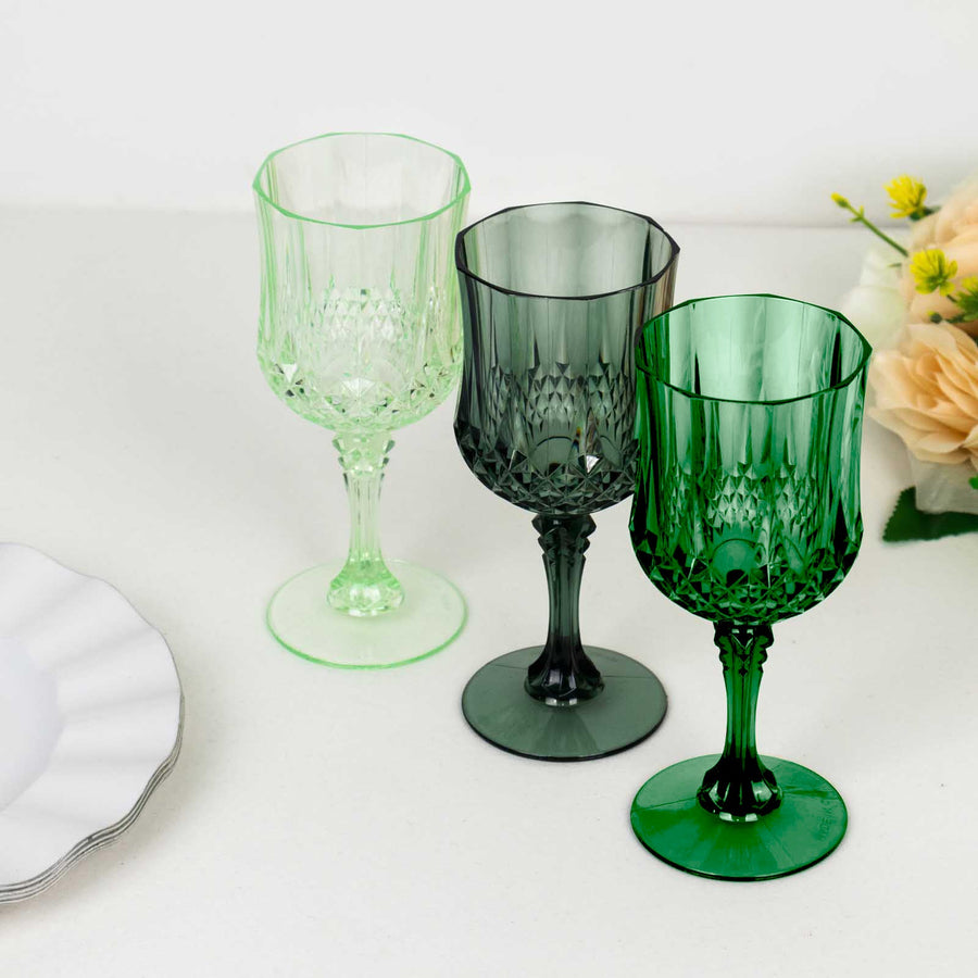 Set of three decorative crystal goblets in green and clear shades.