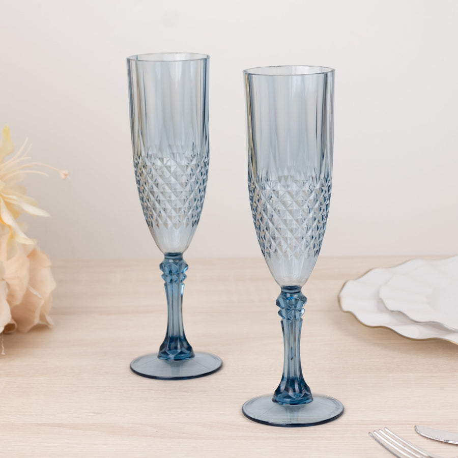 Blue crystal champagne flutes with textured design on a wooden table.