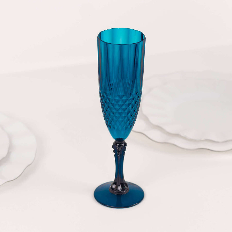 Blue crystal champagne flute on a plain backdrop.