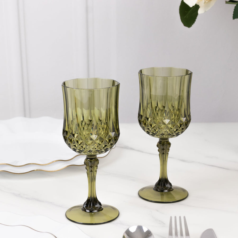 Green crystal goblets on a marble table setting with elegant dinnerware.